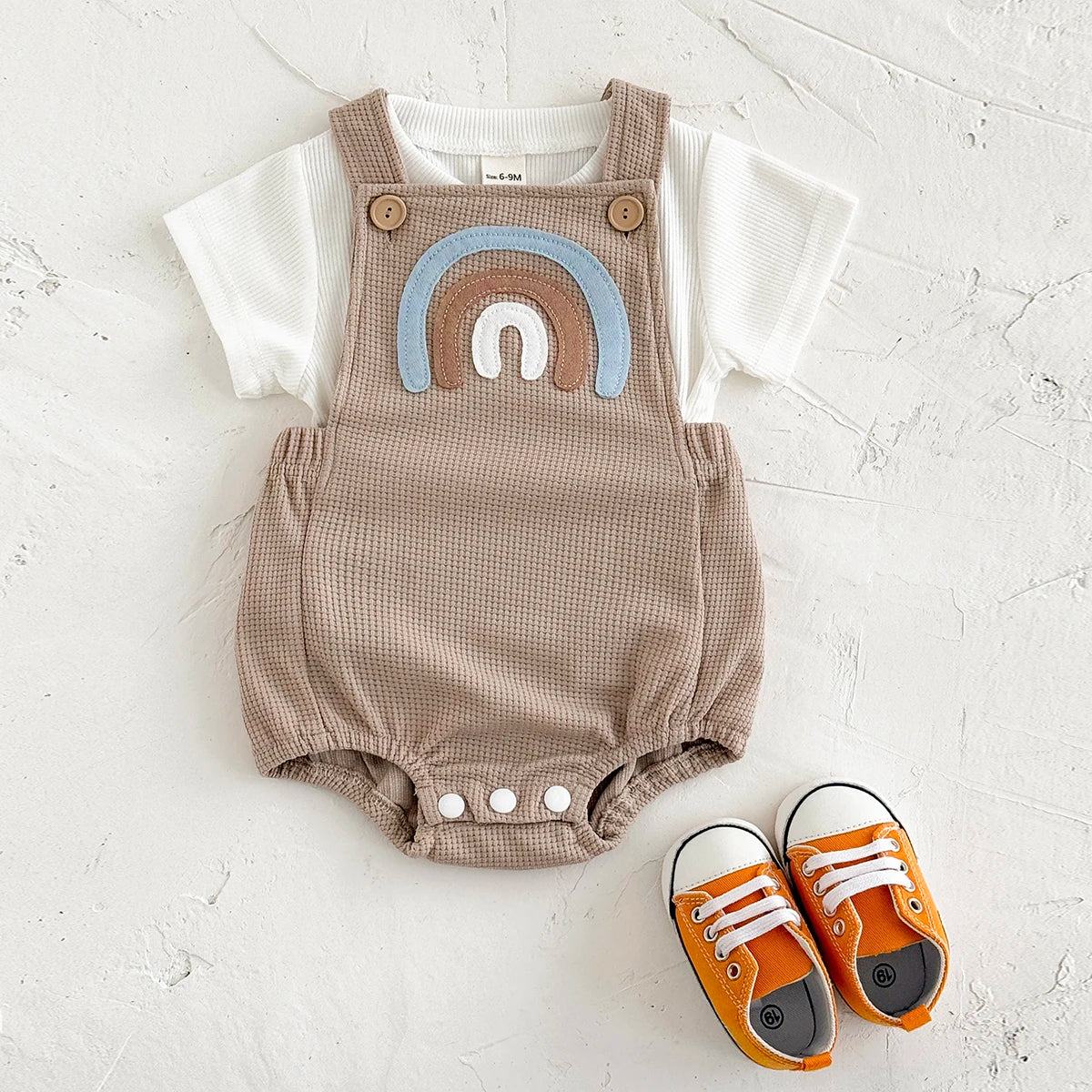Children's summer outfit - suspender jumpsuit with striped t-shirt and rainbow patch.