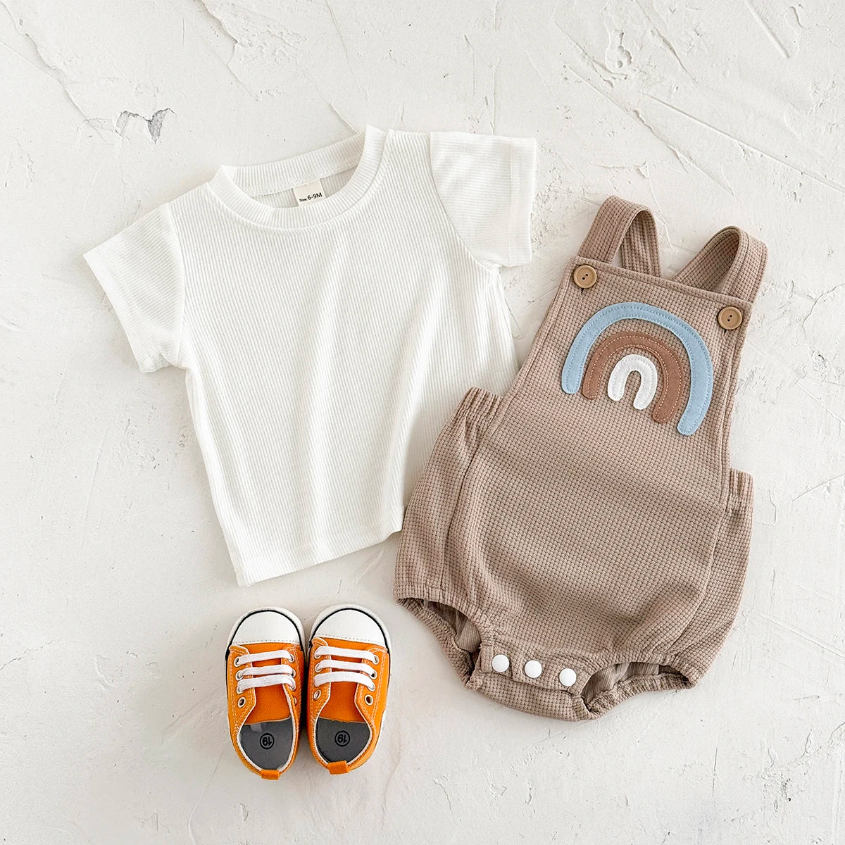 Children's summer outfit - suspender jumpsuit with striped t-shirt and rainbow patch.